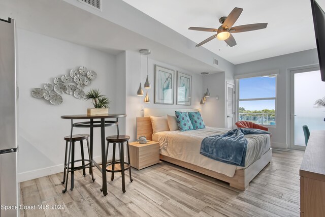 bedroom with ceiling fan, light hardwood / wood-style flooring, and stainless steel fridge