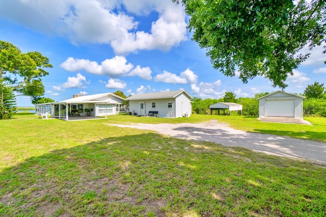 view of yard featuring a garage, a carport, and an outbuilding