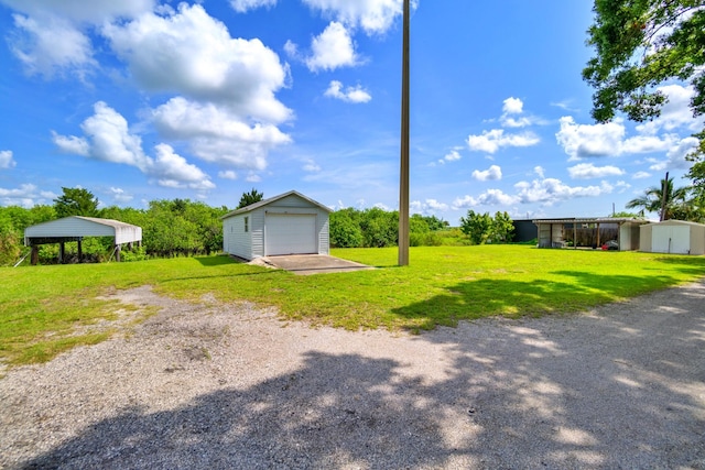 view of yard featuring a carport, a garage, and an outbuilding