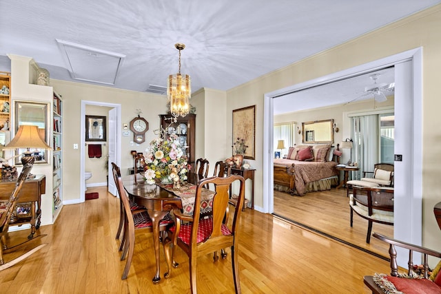 dining space with crown molding, ceiling fan with notable chandelier, and light hardwood / wood-style floors