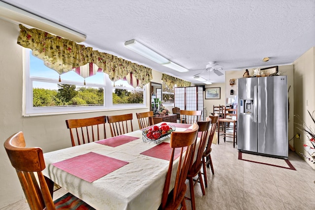 dining room featuring ceiling fan and a textured ceiling