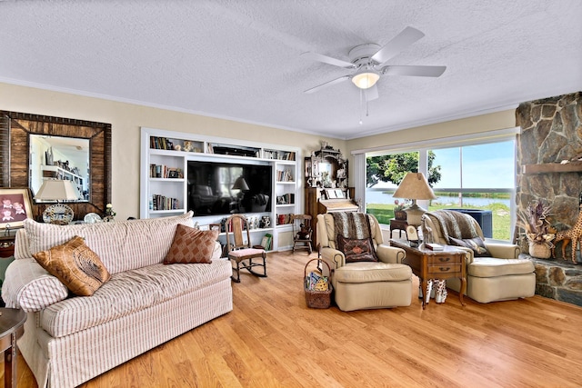 living room featuring ceiling fan, crown molding, light hardwood / wood-style floors, and a textured ceiling