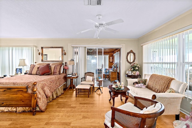 bedroom featuring multiple windows, crown molding, access to outside, and light hardwood / wood-style flooring