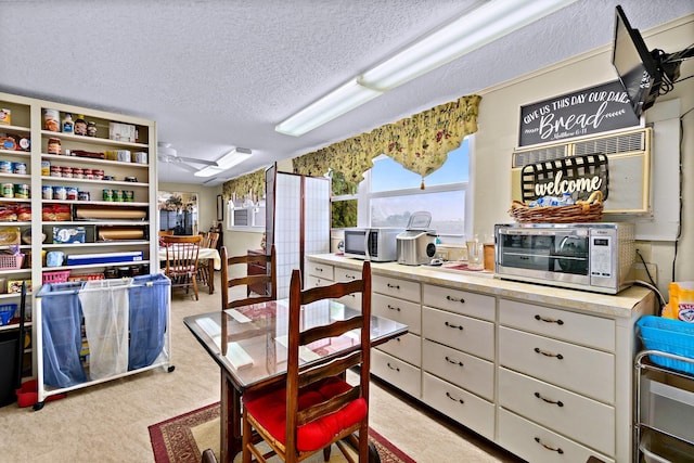 dining space with light colored carpet and a textured ceiling