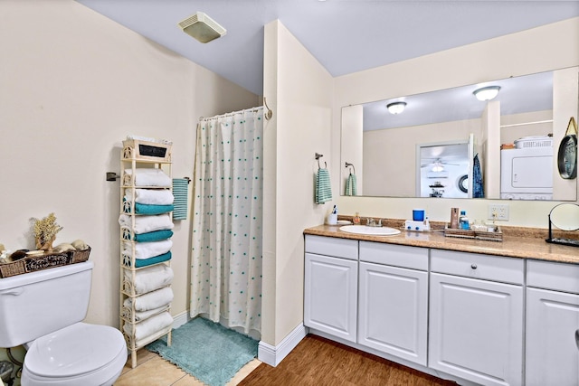 bathroom with hardwood / wood-style flooring, a shower with shower curtain, vanity, washer / dryer, and toilet