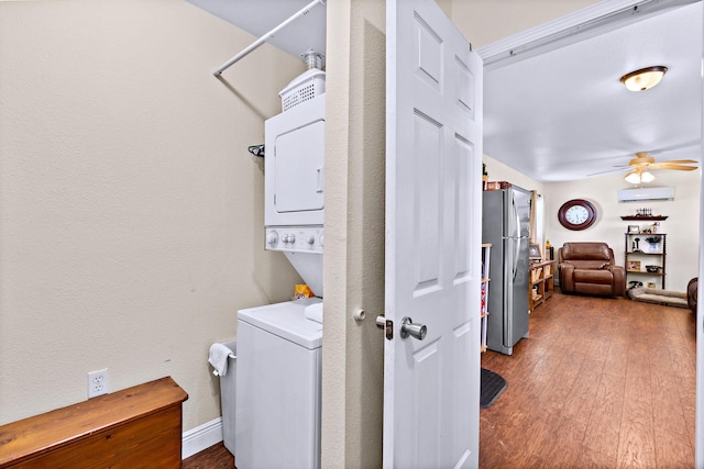 laundry room featuring stacked washer / dryer, dark hardwood / wood-style flooring, an AC wall unit, and ceiling fan