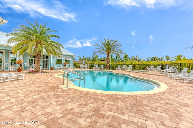 pool featuring fence and a patio