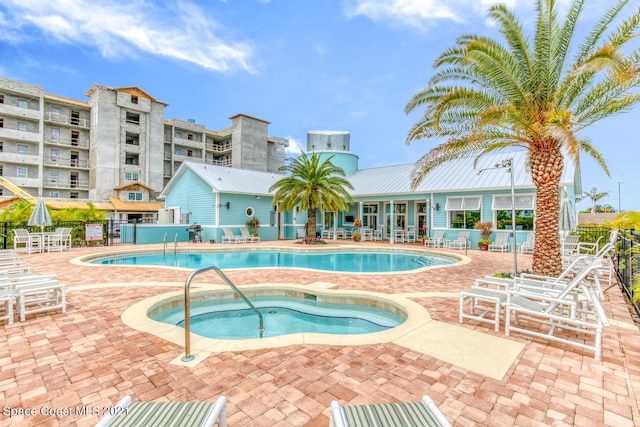 view of swimming pool featuring a patio area and a community hot tub