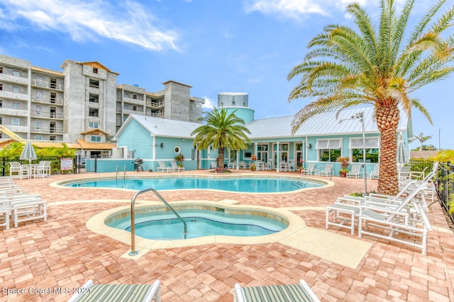community pool featuring a patio area, a community hot tub, and fence
