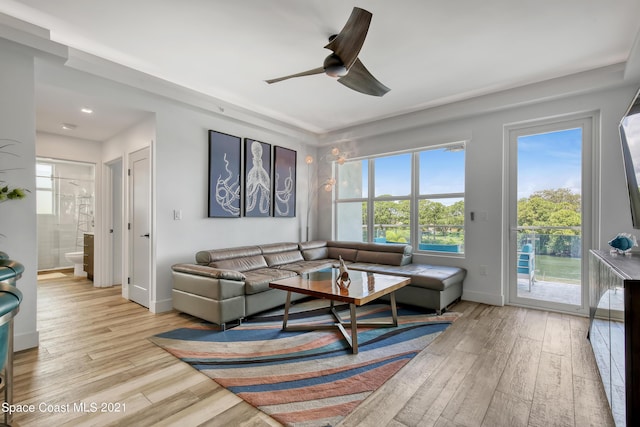 living room featuring a ceiling fan, light wood-style flooring, and baseboards
