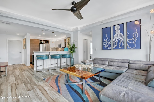 living area with recessed lighting, ceiling fan, visible vents, and light wood-style floors