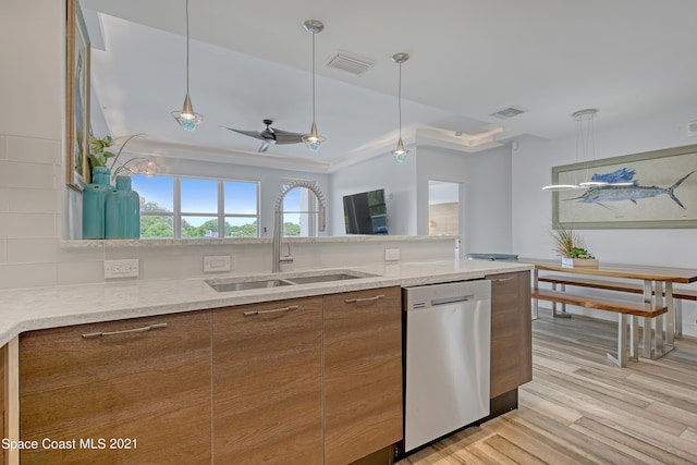 kitchen featuring dishwasher, a sink, brown cabinetry, and visible vents
