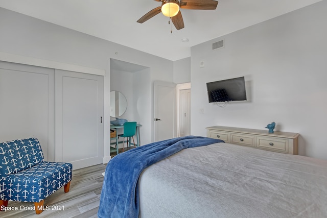 bedroom with light hardwood / wood-style flooring, a closet, and ceiling fan