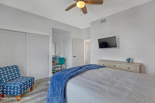 bedroom featuring wood finished floors, a closet, ceiling fan, and visible vents