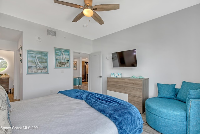 bedroom with a ceiling fan, wood finished floors, and visible vents