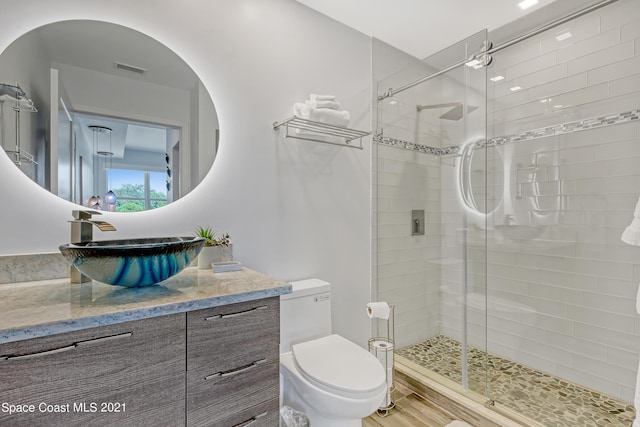 bathroom with a stall shower, visible vents, toilet, and vanity