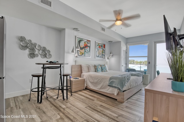 bedroom with stainless steel fridge, light hardwood / wood-style floors, access to exterior, and ceiling fan