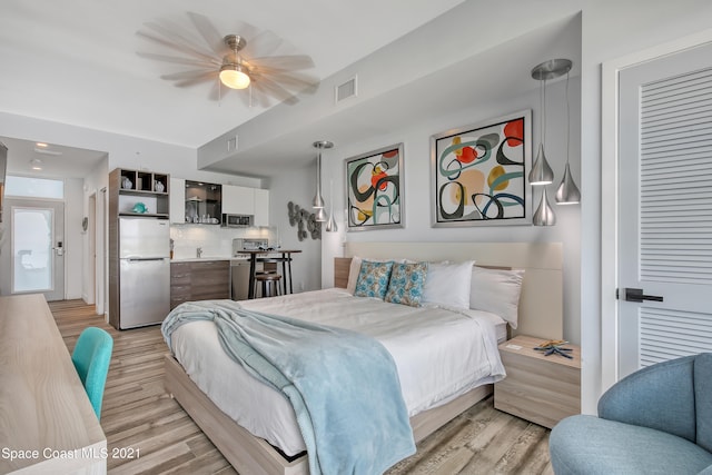 bedroom with stainless steel refrigerator, ceiling fan, and light hardwood / wood-style flooring