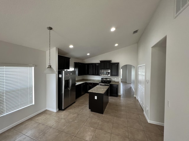 kitchen with light tile patterned flooring, appliances with stainless steel finishes, hanging light fixtures, vaulted ceiling, and a center island