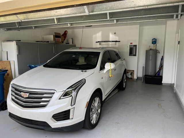 garage with electric water heater and electric panel