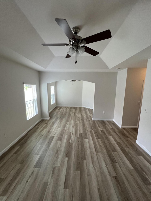 unfurnished living room with ceiling fan, wood-type flooring, and vaulted ceiling