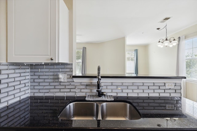 kitchen with white cabinetry, sink, and decorative backsplash