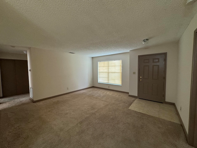 carpeted foyer featuring a textured ceiling