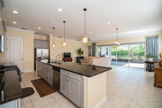 kitchen featuring appliances with stainless steel finishes, sink, dark stone countertops, and gray cabinets