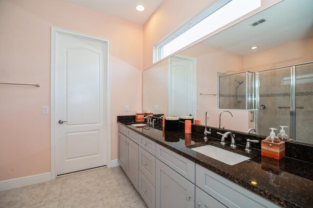 bathroom featuring double vanity, walk in shower, and tile patterned floors