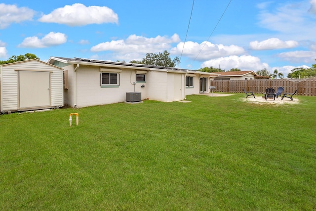 back of house with a lawn, a storage shed, a patio area, and central air condition unit