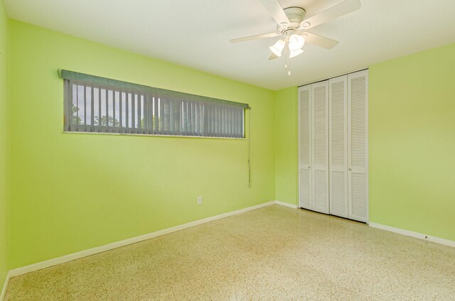 unfurnished bedroom featuring ceiling fan and a closet