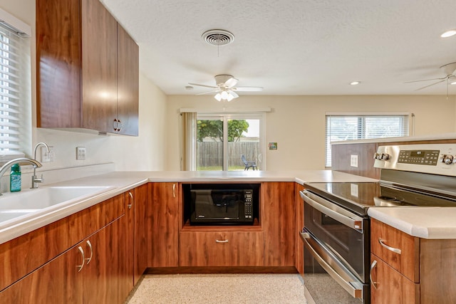 kitchen with ceiling fan, stainless steel range with electric stovetop, and kitchen peninsula