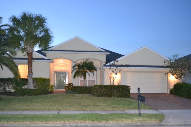 view of front of house featuring a garage and a front lawn