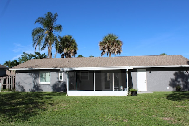 rear view of house with a yard and a sunroom