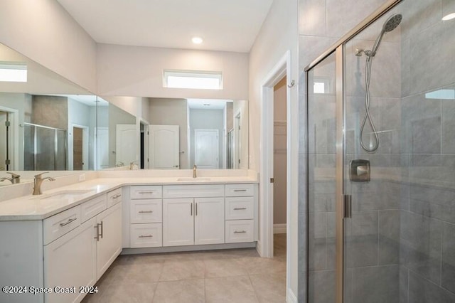 bathroom featuring vanity, a shower with shower door, and tile patterned floors