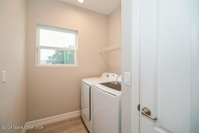 laundry room with light wood-type flooring and washer and dryer