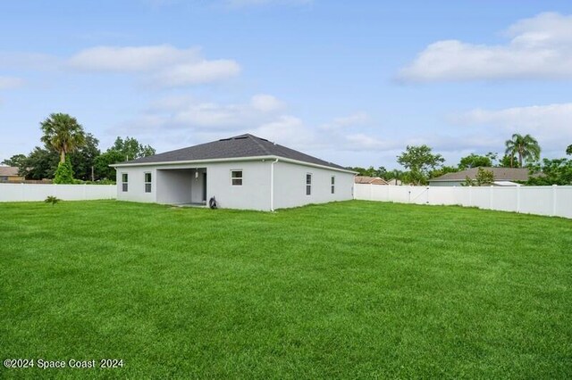 rear view of house featuring a lawn