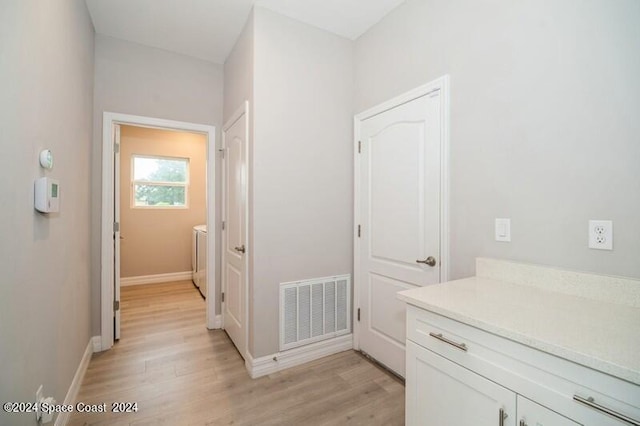 corridor featuring light wood-type flooring and washer / clothes dryer