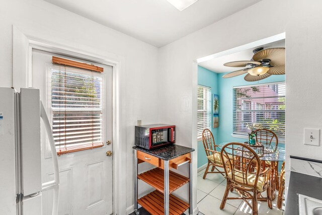 dining area with light tile patterned floors and ceiling fan