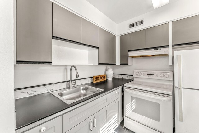 kitchen featuring range with electric stovetop, gray cabinets, white refrigerator, and sink