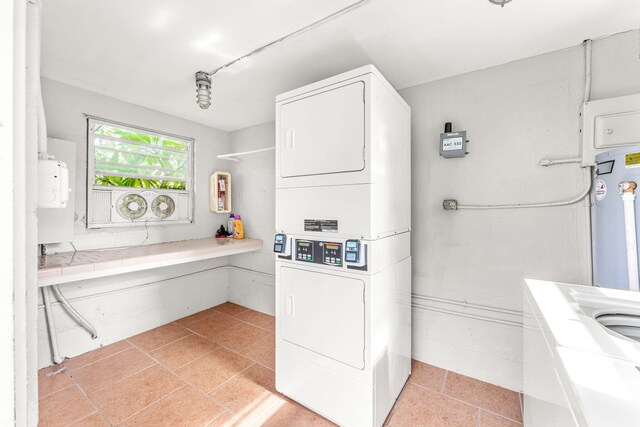 laundry area with light tile patterned flooring and stacked washer and clothes dryer