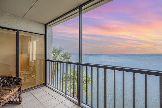 sunroom / solarium featuring a water view