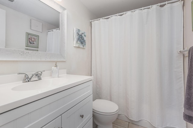 bathroom with tile patterned flooring, vanity, and toilet