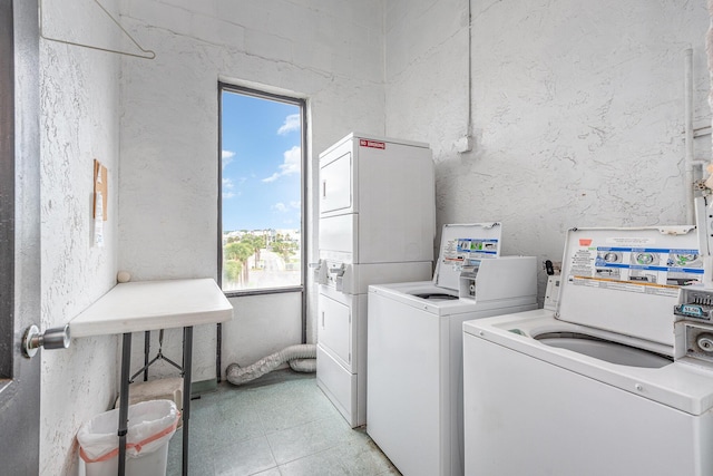 clothes washing area featuring stacked washer and clothes dryer, light tile patterned floors, and independent washer and dryer