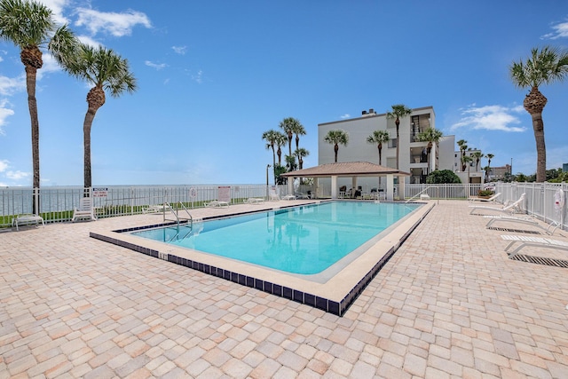 view of pool with a patio and a water view