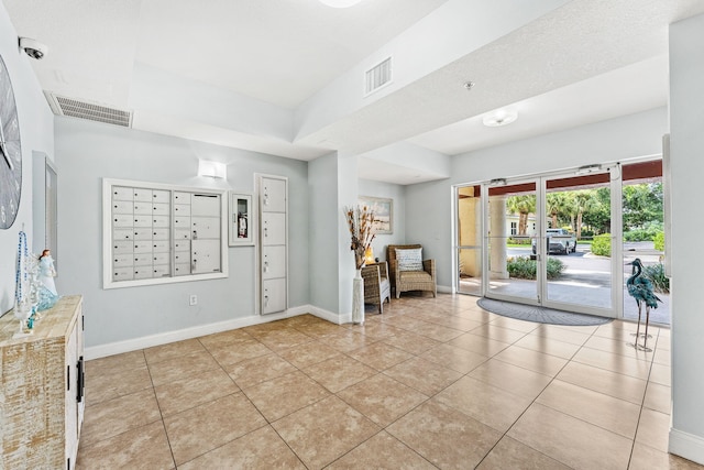 tiled foyer with a mail area