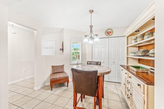 tiled dining area featuring an inviting chandelier