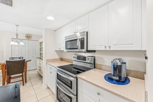 kitchen with white cabinetry, hanging light fixtures, stainless steel appliances, and light tile patterned flooring