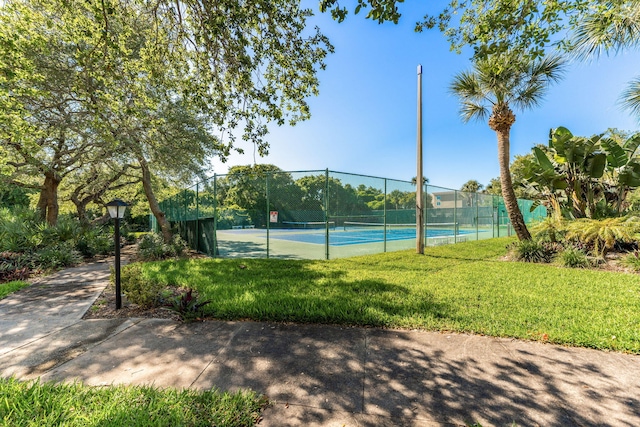 view of tennis court with a yard