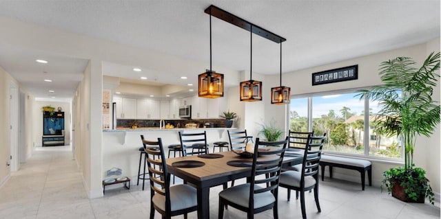 tiled dining room with a textured ceiling